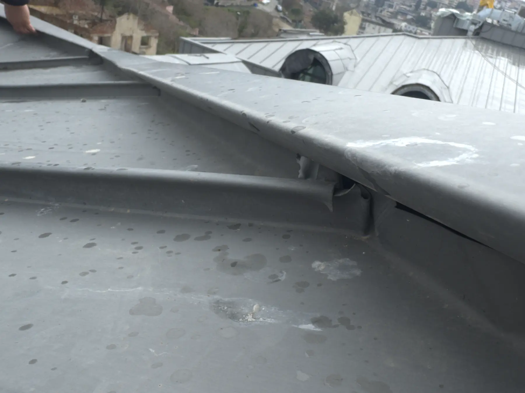 Open and discontinuous junction in a standing seam metal roof